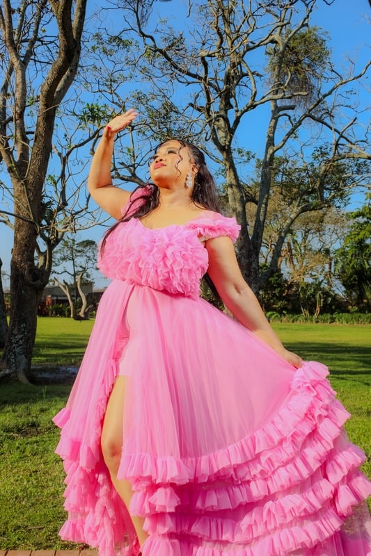 Ethereal Elegant — subject in a flowing pink gown bathed in golden sunlight against bare trees